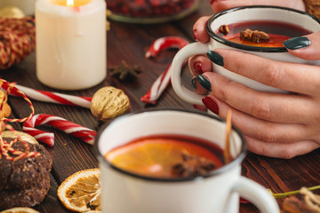 Woman holding cup with mulled wine in her hands