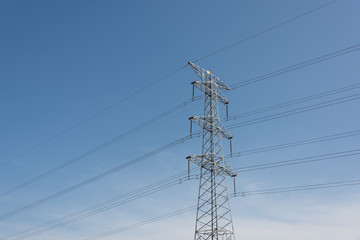 A large metal high voltage transmission tower close-up in a cloudless sky