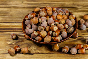Hazelnuts in ceramic plate on a wooden table