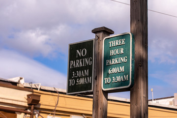 Posted parking sign on a street of Lahaina, Maui. A two side wooden sign read 