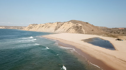 Aerial drone view of surfers beach, calm water and geology and typical vegetation of Angola