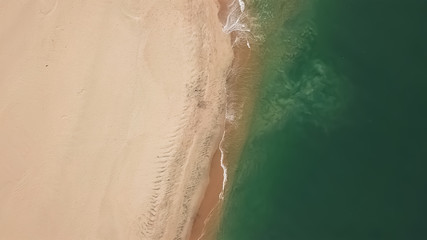 Aerial view, shot with drone on the coast of Angola, water with waves on the beach