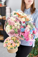 Four of beautiful luxury bouquet. Mixed flowers in woman hands. the work of the florist at a flower shop.