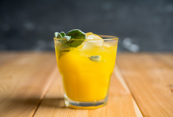 Sweet old-fashioned cocktail with orange and sage. Selective focus. Shallow depth of field.