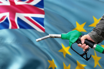 Tuvalu gas station. Man pumping gasoline fuel in car with national flag background. Oil prices...