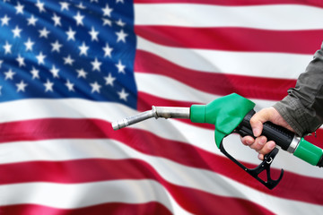 United States gas station. Man pumping gasoline fuel in car with national flag background. Oil prices concept.