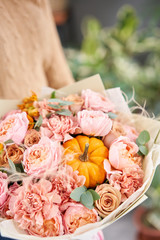 Autumn bouquet of mixed flowers in womans hands. The work of the florist at a flower shop. Fresh cut flower.