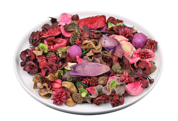 Fragrant dried red  tropical forest flowers  nuts and fruits for Xmas decorations in a ceramic plate  isolated macro