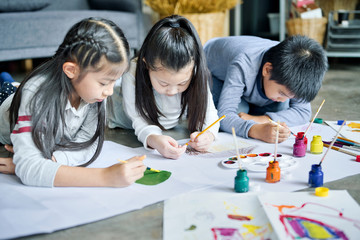 Fototapeta premium Asian family with cute kids painting art in living room at home