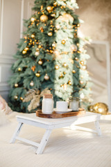 Romantic Breakfast in a bed. Romantic white bedroom decorated for New Year Celebrating. Christmas mood at home. White bedroom and Christmas spruces. 