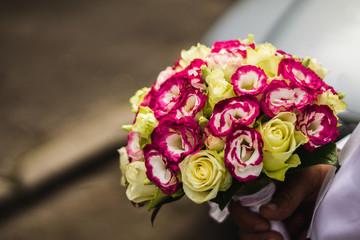 Man holding brides flower bouquet.