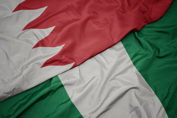Fototapeta premium waving colorful flag of nigeria and national flag of bahrain.