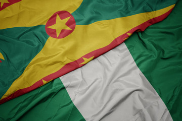 Obraz premium waving colorful flag of nigeria and national flag of grenada.