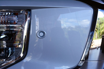 the small sensor on white plastic bumper at the front of the car