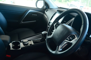 Fototapeta na wymiar the black leather at middle of the steering wheel inside of new car passenger room