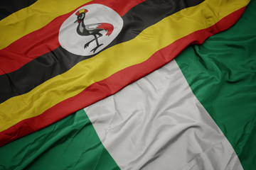 waving colorful flag of nigeria and national flag of uganda.