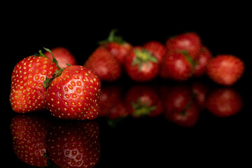 Lot of whole fresh red strawberry isolated on black glass