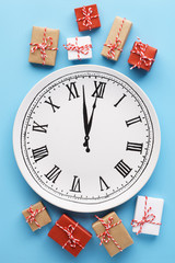 Gift boxes around a plate clock on light blue background.