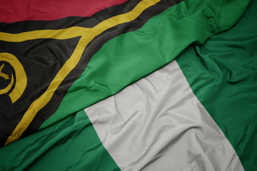 waving colorful flag of nigeria and national flag of Vanuatu .