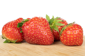 Lot of whole fresh red strawberry on bamboo cutting board isolated on white background