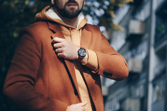street style 2019 fashion, close up detail of men's fashion accessory. man checking the time on his leather wrist watch.