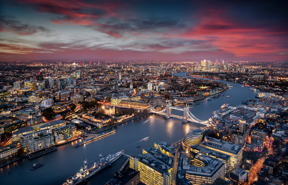 Blick über London: die beleuchtete Skyline von der Tower Brücke entlang der Themse zu den Wolkenkratzern von Canary Wharf am Abend © moofushi