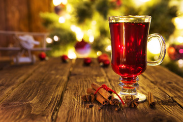 Christmas mulled wine on defocused christmas tree background.