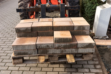 Forklift with new paving stones on the wooden pallet