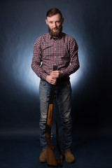 Man with shotgun on a dark background