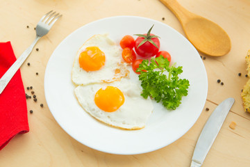 Fried eggs with white bread on plate on wooden table