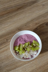 berry smoothie bowl with kiwi and coconut slices