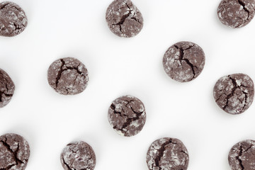 Pattern from chocolate crinkle cookies, white background. Christmas, recipe concept. Top view, flat lay, copy space