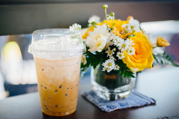 Iced coffee with iced Thai tea on the table paired with flower vases