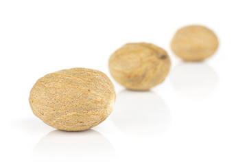 Group of three whole dry brown nutmeg isolated on white background
