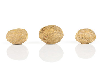 Group of three whole dry brown nutmeg isolated on white background