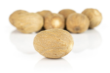 Lot of whole dry brown nutmeg isolated on white background