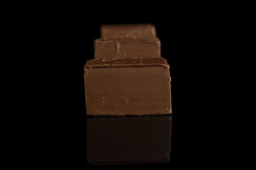 Group of three whole sweet brown viennese nougat isolated on black glass