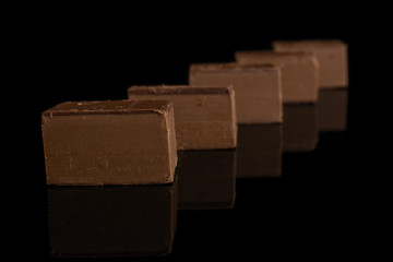 Group of five whole sweet brown viennese nougat isolated on black glass