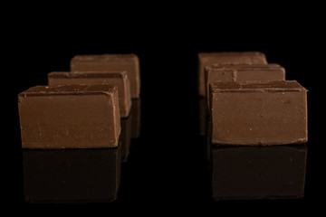 Group of six whole sweet brown viennese nougat isolated on black glass