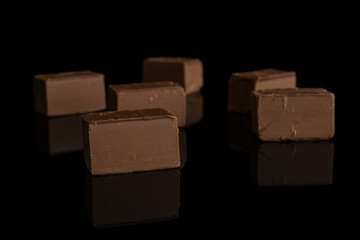 Group of six whole sweet brown viennese nougat isolated on black glass