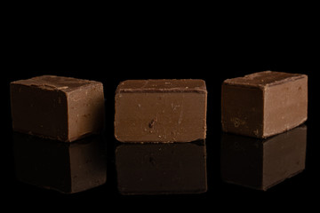 Group of three whole sweet brown viennese nougat isolated on black glass