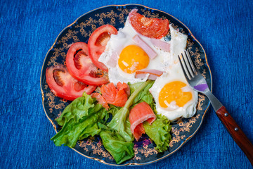 Fried eggs with tomatoes and lettuce