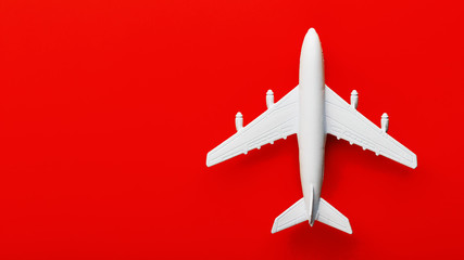 White passenger model airplane on a bright red background. Free space for text