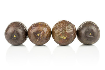 Group of four whole sweet dark purple passion fruit isolated on white background
