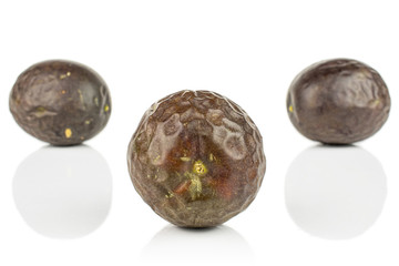 Group of three whole sweet dark purple passion fruit isolated on white background