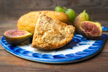 cheese, figs, grapes and knife on cutting board