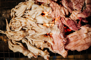 There was a man's hand pinging meat for his friends to eat at the Kamas party.