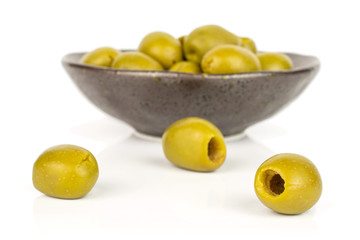 Lot of whole pitted green olive in dark ceramic bowl isolated on white background