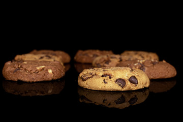 Group of eight whole sweet brown cookie front focus isolated on black glass