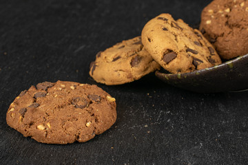 Group of four whole sweet brown cookie in glazed bowl flatlay on grey stone